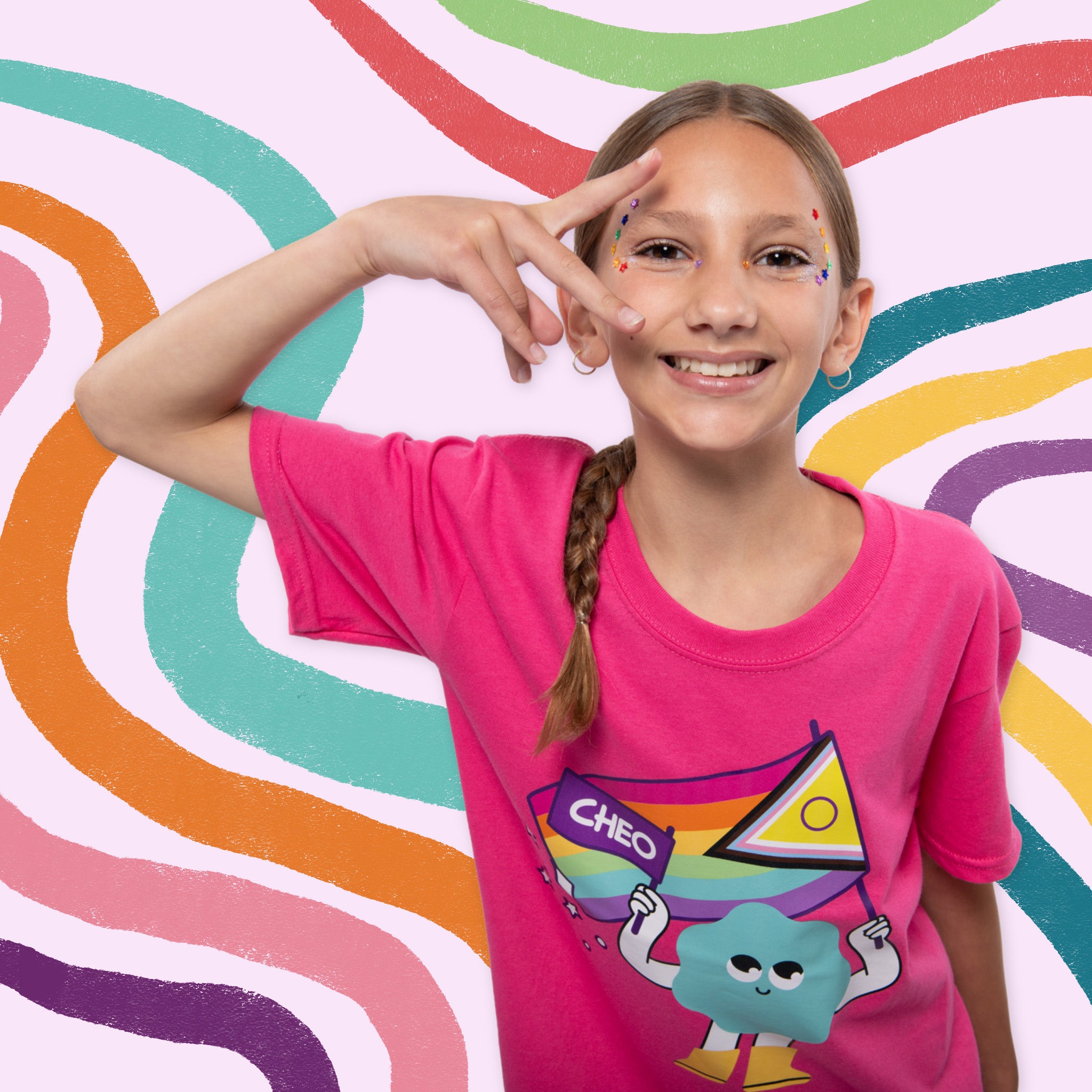 A smiling young girl with a braid poses in a bright pink t-shirt featuring a cartoon character and the name 'CHEO' against a colorful wavy background.